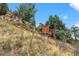 Exterior view of mountain property featuring unique hillside cabin with deck at 7282 Silverhorn Dr, Evergreen, CO 80439