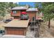 Back exterior of a wood home featuring decks, solar panels, and garage at 7282 Silverhorn Dr, Evergreen, CO 80439