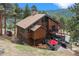 Beautiful wood home featuring a multi-level deck, outdoor seating, and mountain views at 7282 Silverhorn Dr, Evergreen, CO 80439