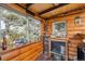 Cozy cabin interior featuring wood paneled walls, decorative fireplace, and bright windows at 7282 Silverhorn Dr, Evergreen, CO 80439