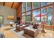 Bright living room with large windows, plush leather seating, and a relaxing atmosphere at 7282 Silverhorn Dr, Evergreen, CO 80439