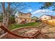 Landscaped backyard with a brick grill, patio seating, and a unique wooden hammock at 4014 S Kirk Way, Aurora, CO 80013