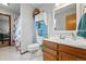 Fun bathroom featuring mushroom shower curtain, open shelving, and wood vanity at 4014 S Kirk Way, Aurora, CO 80013