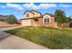 Suburban home with well-kept lawn, two-car garage, and traditional architecture under a bright sky at 4014 S Kirk Way, Aurora, CO 80013