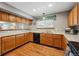 Efficient kitchen with wood cabinets, a window above the sink, and a breakfast bar at 4014 S Kirk Way, Aurora, CO 80013