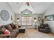 Cozy living room with vaulted ceiling, window with stained glass detail, and comfortable seating at 4014 S Kirk Way, Aurora, CO 80013