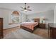 Comfortable primary bedroom with a ceiling fan, a large window, and neutral carpet at 4014 S Kirk Way, Aurora, CO 80013