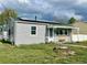 View of the front of this charming home, showcasing its lovely yard, solar panels and covered porch at 98 N 12Th Ave, Brighton, CO 80601