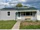 Charming single-story home featuring solar panels, a green roof, and a welcoming front porch with yellow bench at 98 N 12Th Ave, Brighton, CO 80601