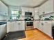 A bright kitchen with white cabinets, stainless steel appliances, and a window with plants at 98 N 12Th Ave, Brighton, CO 80601