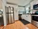 White cabinet kitchen with stainless steel appliances and wood-look flooring, ready for cooking and entertaining at 98 N 12Th Ave, Brighton, CO 80601