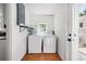 Well-lit laundry room with white washer and dryer, and hardwood floors at 98 N 12Th Ave, Brighton, CO 80601