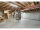 Unfinished basement with concrete walls and floors, exposed beams, and visible utilities at 8441 Timberwood St, Littleton, CO 80126