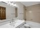 Bathroom featuring a modern vanity with a single sink and framed mirror with lighting, along with a tub and shower at 8441 Timberwood St, Littleton, CO 80126