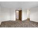 A carpeted bedroom features neutral walls and trim plus an entry way door to other rooms in the house at 8441 Timberwood St, Littleton, CO 80126