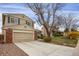 Traditional two-story home boasting an attached garage, neutral siding, brick accents, and a paved driveway at 8441 Timberwood St, Littleton, CO 80126