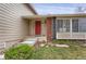 Inviting front entrance featuring a vibrant red door with wreath, brick accents, and well-maintained landscaping at 8441 Timberwood St, Littleton, CO 80126