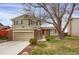 Charming two-story home featuring neutral siding, brick accents, an attached garage, and a well-manicured lawn at 8441 Timberwood St, Littleton, CO 80126