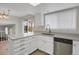 Bright kitchen features white cabinets, stainless steel dishwasher and light countertop by a large window at 8441 Timberwood St, Littleton, CO 80126