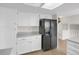 Bright kitchen features white cabinets, light countertop and black refrigerator at 8441 Timberwood St, Littleton, CO 80126