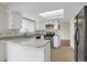 Updated kitchen features stainless steel appliances, white cabinetry, a skylight, and a breakfast bar at 8441 Timberwood St, Littleton, CO 80126