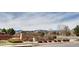 Inviting entrance to Sunrise Ridge featuring a stone sign, manicured landscaping, and a view of the surrounding neighborhood at 6220 Salvia St, Arvada, CO 80403