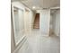 Finished basement hallway featuring tile floor, access to the stairs, and multiple rooms at 3000 Billings St, Aurora, CO 80011