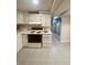 Basement kitchen area with white cabinets, tile floors and adjacent access to utility area at 3000 Billings St, Aurora, CO 80011