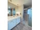 Bathroom featuring double sinks, granite countertop, and walk-in shower at 3000 Billings St, Aurora, CO 80011