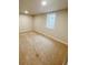 A light beige carpeted room with one window and neutral walls at 3000 Billings St, Aurora, CO 80011