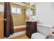 Well-lit bathroom featuring a shower-tub combo, a single sink vanity, and a tiled backsplash at 2813 S Zenobia St, Denver, CO 80236