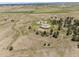 Expansive aerial view highlighting the home, surrounding trees, and vast, open land at 30999 Kootney St, Elizabeth, CO 80107