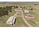 Wide aerial shot showcases the property with multiple structures, open land, and mountain views at 30999 Kootney St, Elizabeth, CO 80107