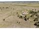 Sweeping aerial view of the property, showcasing its expansive land, multiple structures, and mature trees at 30999 Kootney St, Elizabeth, CO 80107