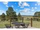 Outdoor seating arrangement on the deck with views of the lush landscape, trees, and mountains beyond at 30999 Kootney St, Elizabeth, CO 80107