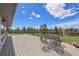 Inviting deck features metal seating with expansive views of the surrounding green fields and trees at 30999 Kootney St, Elizabeth, CO 80107