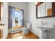 Cozy bathroom with a pedestal sink, toilet, and window with natural light and charming curtains at 30999 Kootney St, Elizabeth, CO 80107