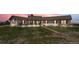 Charming single-story home with a metal roof, large windows, red shutters and well-kept lawn at sunset at 30999 Kootney St, Elizabeth, CO 80107