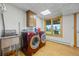 Practical laundry room equipped with a sink, washer, dryer, and a bright window overlooking nature at 30999 Kootney St, Elizabeth, CO 80107