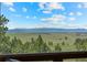 Stunning mountain views are showcased from the home's windows framed by lush green trees at 30999 Kootney St, Elizabeth, CO 80107