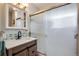Bathroom featuring a vanity with marble countertop, wood cabinets and tiled shower at 6445 Second St, Louviers, CO 80131