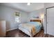 Well-lit bedroom featuring a large window, hardwood flooring, and beach-themed accents at 6445 Second St, Louviers, CO 80131