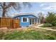 Blue home with white trim and privacy fence, creating a cozy outdoor space at 6445 Second St, Louviers, CO 80131