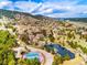 Scenic aerial view of a community featuring a picturesque pond, tennis courts, and stunning mountain views in the background at 23612 Pondview Pl # A, Golden, CO 80401