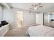 Bright bedroom featuring plush carpet, ceiling fan, and a convenient ensuite bathroom at 23612 Pondview Pl # A, Golden, CO 80401