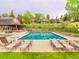 Inviting community pool surrounded by lounge chairs, with a building and lush landscaping in the background at 23612 Pondview Pl # A, Golden, CO 80401