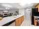 Open kitchen with wood cabinets, stainless appliances, tile flooring and eat-in counter at 23612 Pondview Pl # A, Golden, CO 80401