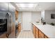 Bright kitchen features stainless steel appliances, wood cabinets, and tile flooring at 23612 Pondview Pl # A, Golden, CO 80401