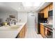 Open kitchen with wood cabinets, stainless appliances, tile flooring and eat-in counter at 23612 Pondview Pl # A, Golden, CO 80401