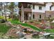 Multi-level backyard features a stone staircase, water feature, grass, and mature landscaping at 646 Ruby Trust Dr, Castle Rock, CO 80108